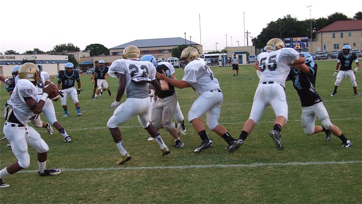 Image: Eric Carson(7) drops back behind Ryheem Walker(22), Kevin Roldan(75) and Zain Byers(55).