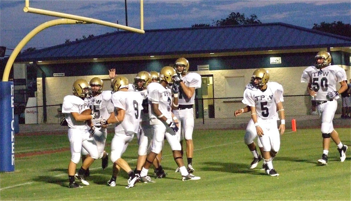 Image: Shad Newman gets congratulated after bowling over a Cougar defender for a touchdown after snagging a nifty pass from teammate Marvin Cox.