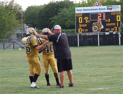 Image: Coach Hank Hollywood love pats Kyle Fortenberry(66) and Jaray Anderson(40) after giving them instructions.