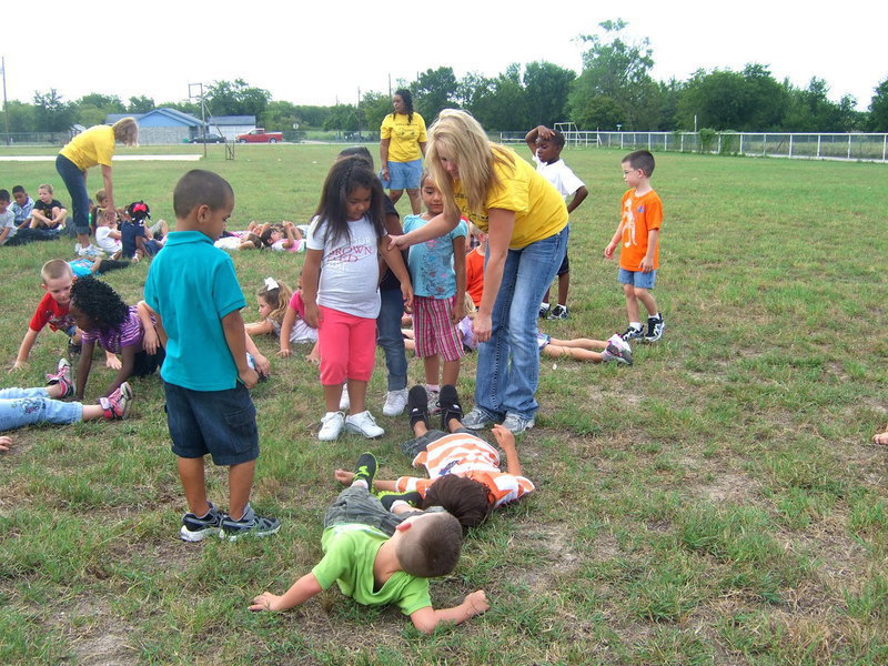 Image: These students are trying to form the letter X.