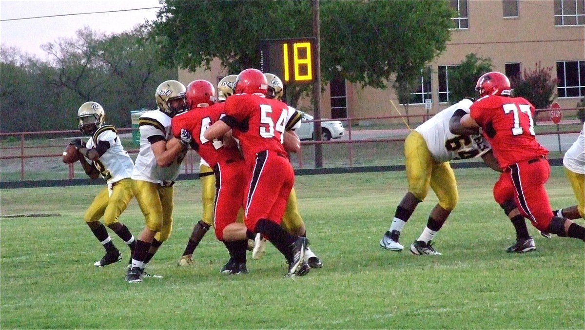 Image: Eric Carson(12) drops back behind his wall of blockers consisting of Zackery Boykin(55), Zain Byers(50), Adrian Reed(64) and running back Ryheem Walker(10).