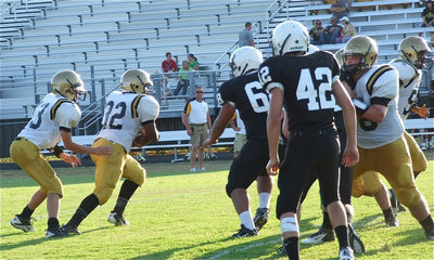 Image: Quarterback Ryan Connor(13) hands off to Billy Morre(32).
