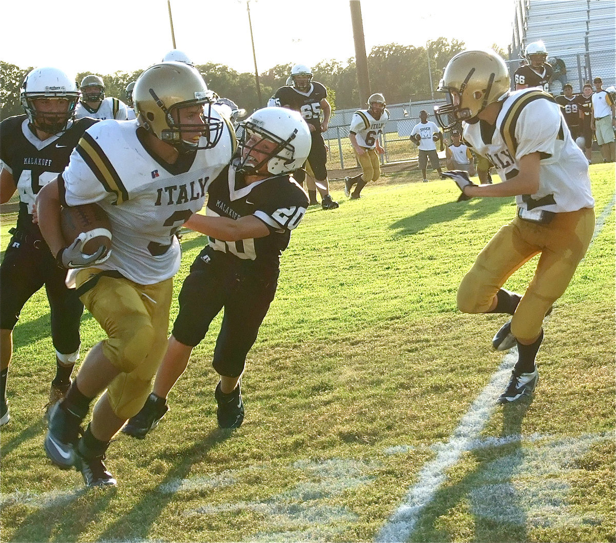 Image: Italy’s Hunter Merimon(3) fights for extra yards with Ty Windham(12) trying to throw a block.