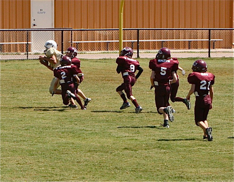 Image: IYAA A-team’s Jonathan Salas(82) draws quite a following of Eagles on his way to the end zone.