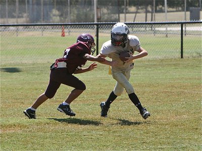 Image: IYAA A-team quarterback Ryder Itson(2) escapes an Eagle defender.