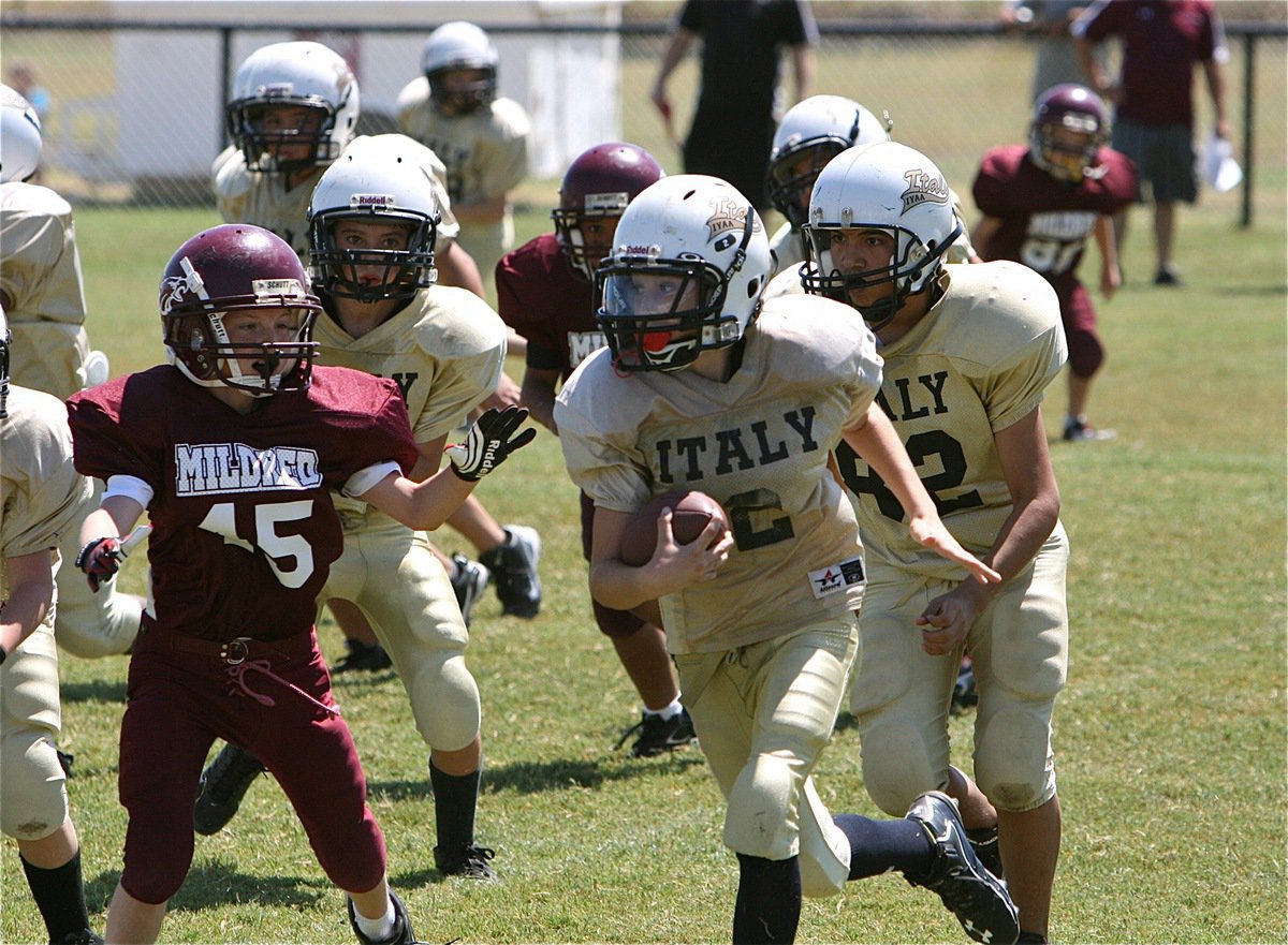 Image: IYAA A-Team quarterback Ryder Itson(2) keeps the ball around the left end.