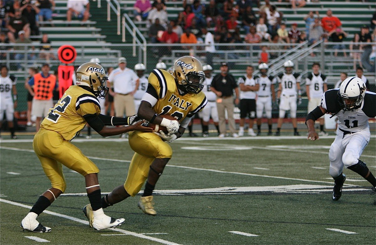 Image: Eric Carson(12) hands off to senior running back Ryheem Walker(10).