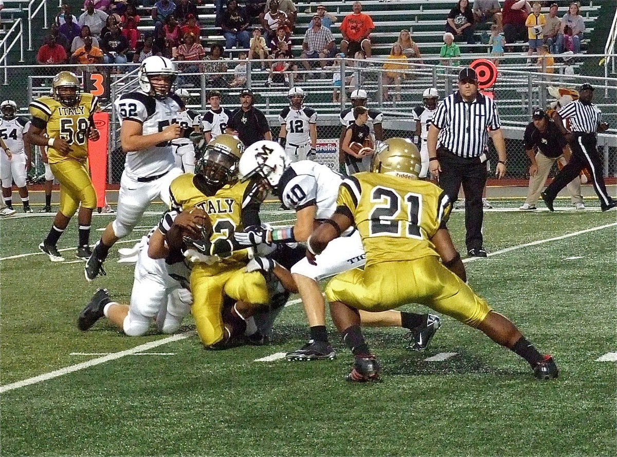 Image: Italy’s Eric Carson(12) scrambles for yards as teammate Jalarnce Lewis(21) attempts to block.