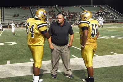 Image: Gladiator line coach Brandon Duncan talks with Adrian Reed(64) and Darol Mayberry(58).