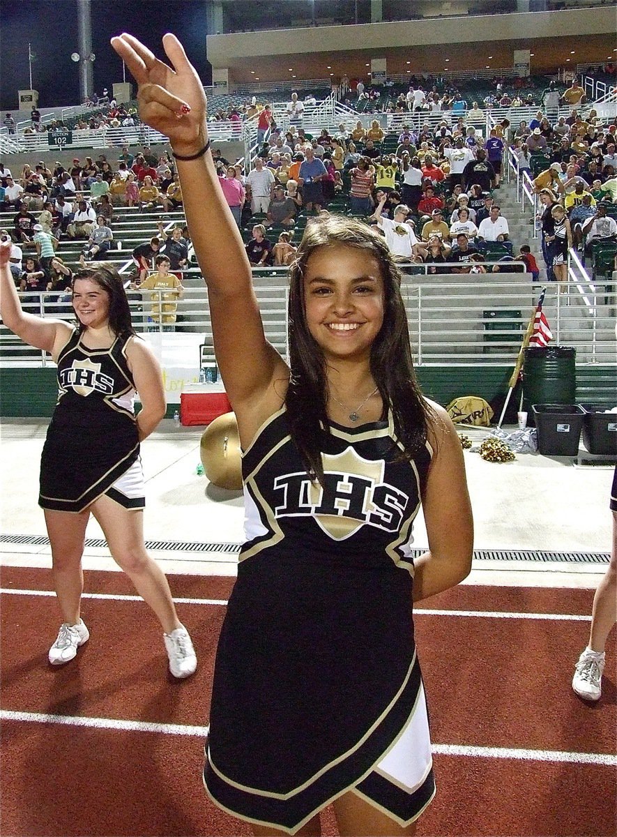 Image: Lady Gladiator Cheerleaders Ashlyn Jacinto (front) and Bailey DeBorde wave their mock swords in support.