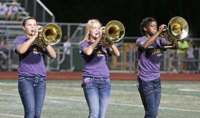 Image: Gladiator Regiment Marching Band members Lillie Perry, Hannah Washington and Kortnei Johnson make some noise during the halftime presentation.