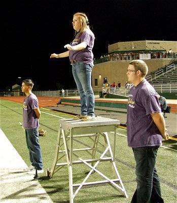 Image: Drum Major Emily Stiles directs the band while being flanked by Joe Celis and Hunter Wood.