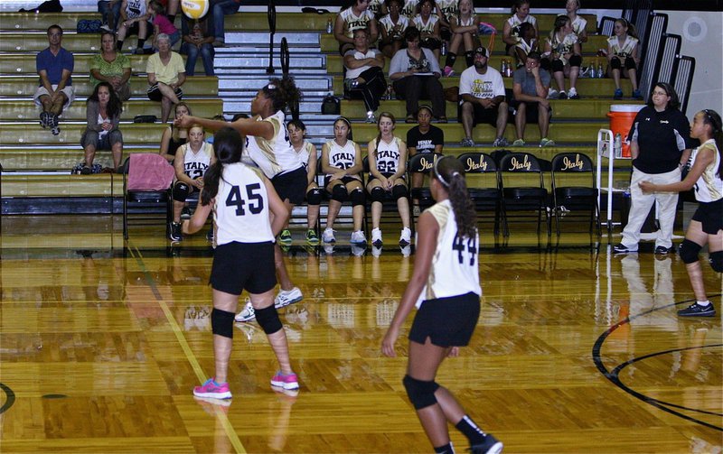 Image: Oleshia Anderson returns the ball for Italy’s 8th graders while coach Lindsey Coffman looks on.