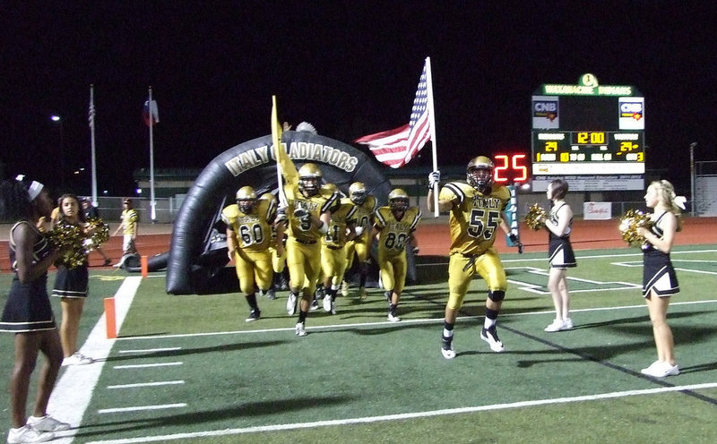 Image: Zackery Boykin(55) and Cole Hopkins(9) raise the flags and lead the Gladiators out for the second half.