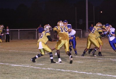 Image: Eric Carson(12) hands off to Ryheem Walker(10) while Darol Mayberry(58) and Cody Medrano(75) double down.