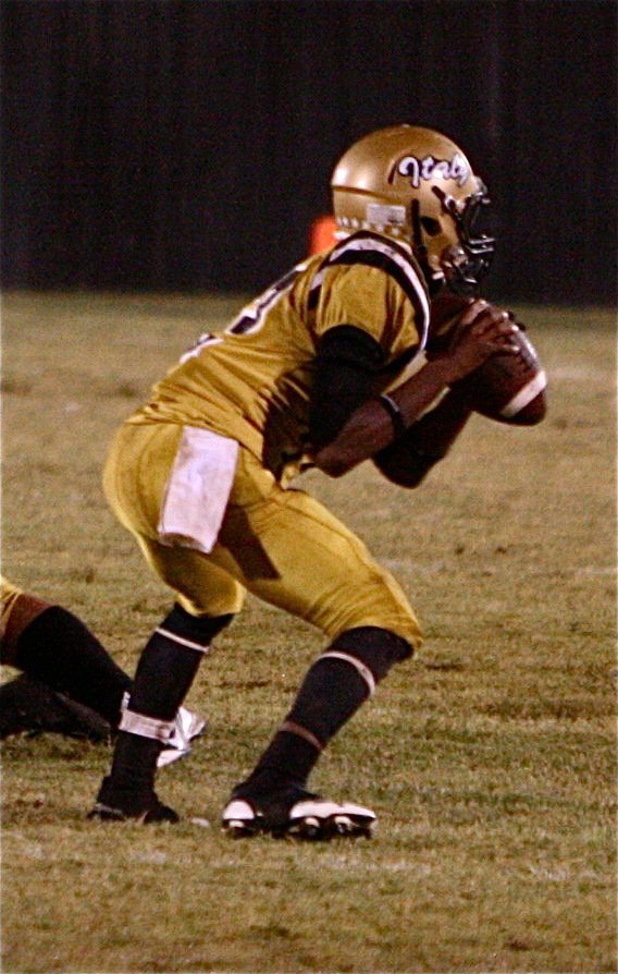 Image: Quarterback Eric Carson(12) sits in the pocket while looking downfield.