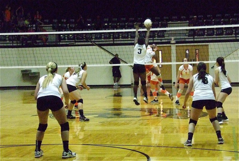 Image: Italy’s Kortnei Johnson(3) leaps at the net for a block attempt.