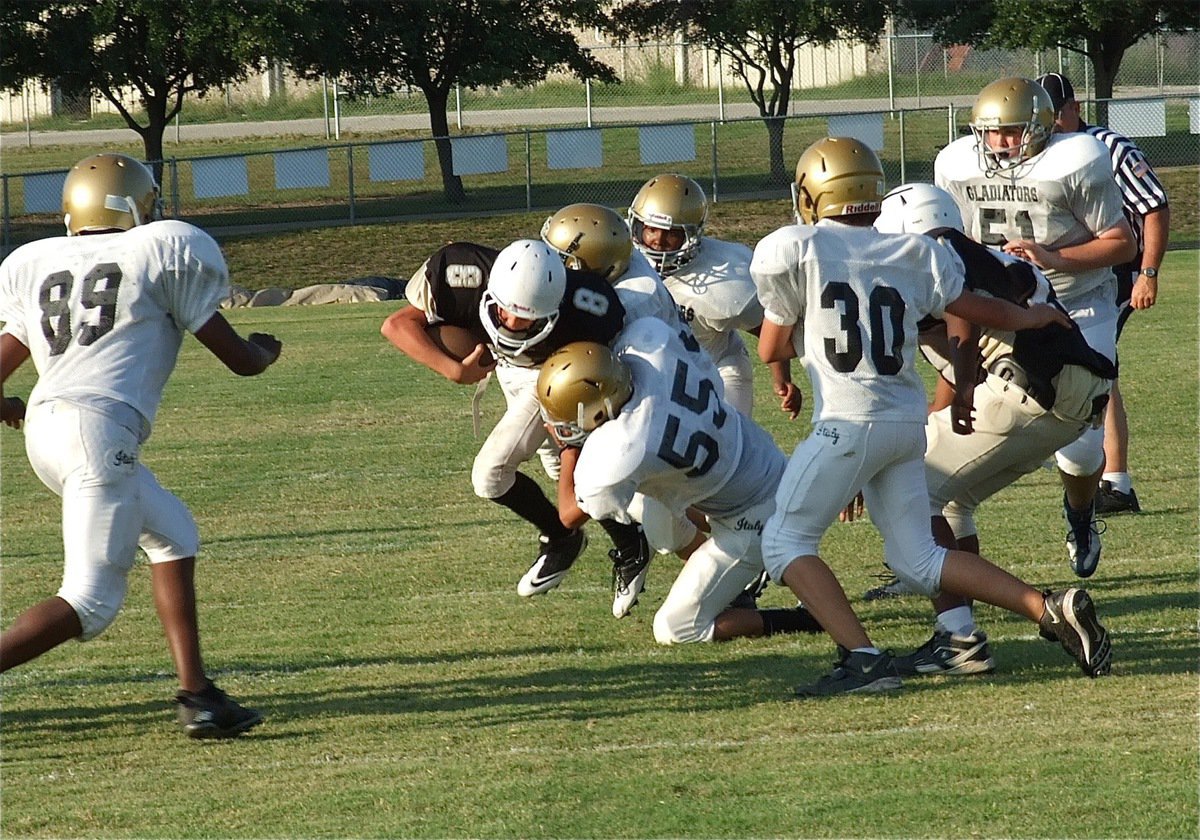 Image: Italy’s David De La Hoya(55) helps tackle the Hubbard quarterback.