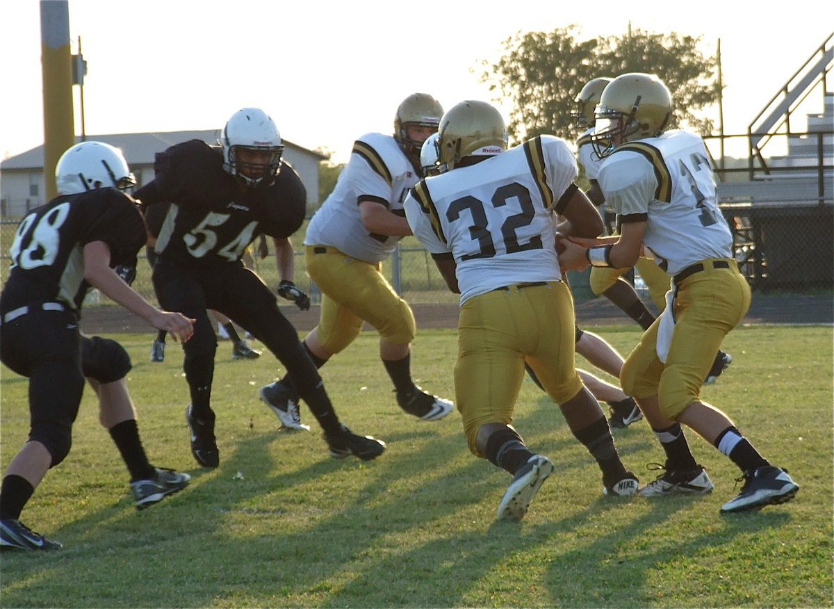 Image: Taking the hand off from Ryan Connor(13) is Billy “Da Bus” Moore(32).