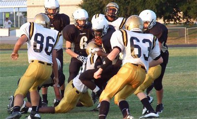 Image: John Hughes(60) drags down a Jaguar ball carrier with Hunter Merimon(86) and John Escamilla(63) ready to assist.