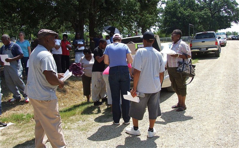 Image: Those attending the rally sign a log book and collect information documenting the disturbing events that have occurred at St. Mary Cemetery.