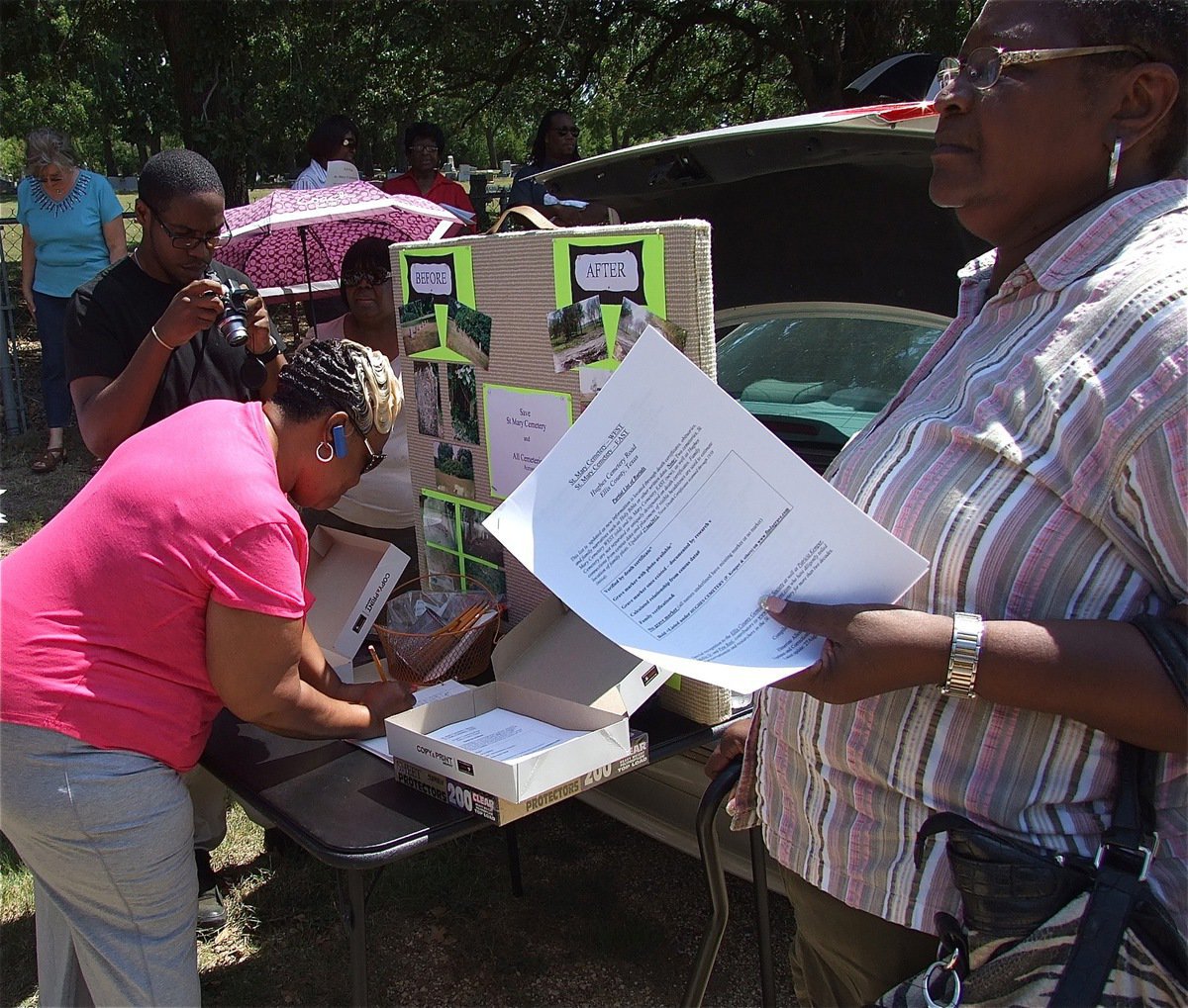 Image: Those attending show their support for the SAVE St. Mary Cemetery cause as Birdie Sneed Montgomery, a 6th generation member of the Rankin Family, signs her name. The Rankin Family descends from Willoughby Rankin, who it is believed to have traveled from Alabama with the family of Fredrick Harrison Rankin in 1823. According to the handbook of the Texas Historical Association, on July 7, 1824, Fredrick Harrison Rankin was a one of *Stephen F. Austin’s Old Three Hundred Colonists. Grave markers and Texas death certificates verify that three of Willoughby Rankin’s children as well as a number of other descendants are buried at St. Mary Cemetery. Members of three younger generations of the Rankin Family currently reside in Milford.