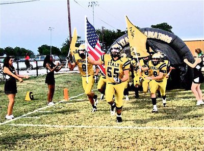 Image: Senior Gladiators Zackery Boykin(55), Cole Hopkins(9) and Hayden Woods(8) hoist the flags and lead the team into battle.