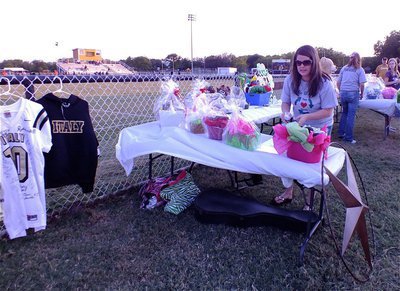 Image: Team Hooker member Tina Long helps setup all the items that were donated for the silent auction.