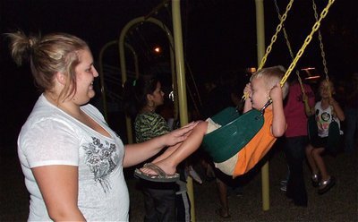 Image: Julia McDaniel pushes her son Kace on the swings as part of the fun and games associated with National Night Out.