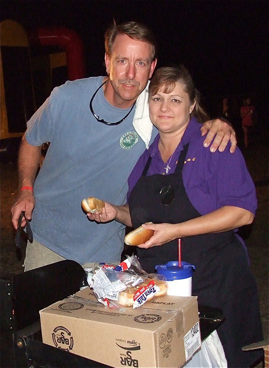 Image: Former IHS classmates Charles Hyles and Flossie Gowin help the Lions Club serve hotdogs during National Night Out.