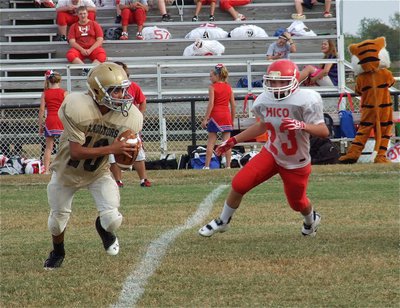 Image: 7th grade quarterback Tylan Wallace(10) avoids a Tiger in pursuit.