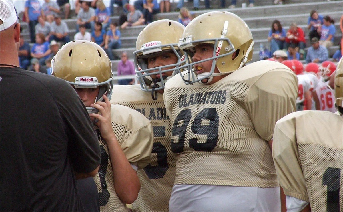 Image: Adrian Acevedo(99) and his teammates take advice from Coach Hank Hollywood.