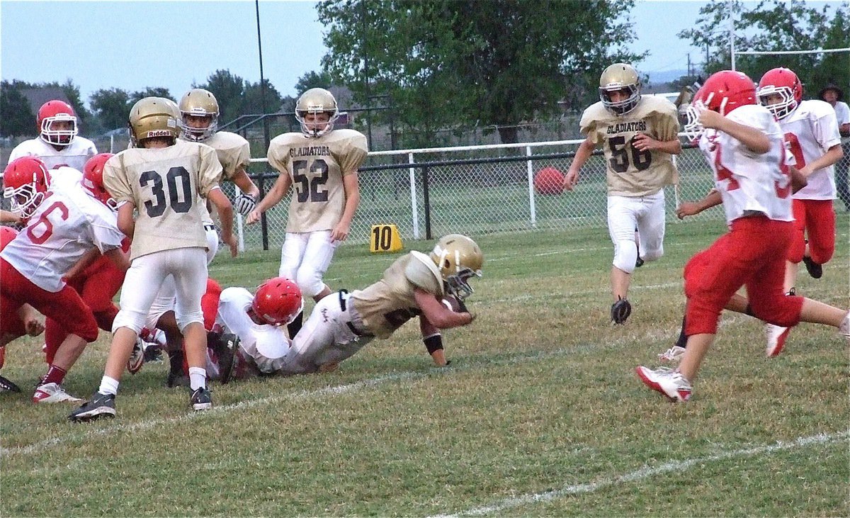 Image: Joseph Celis(24) lunges for an extra yard against the Tigers during the 8th grade game.