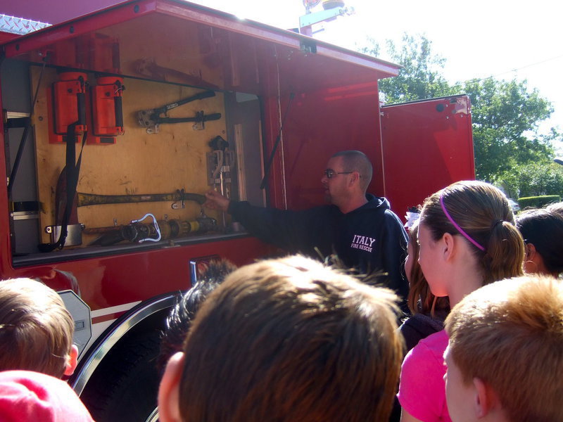 Image: Italy Volunteer Fireman Brad Chambers showing the students the tools the firemen use.
