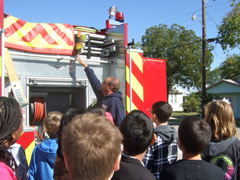 Image: Fireman Brad Chambers showing students where the extra hoses are kept.