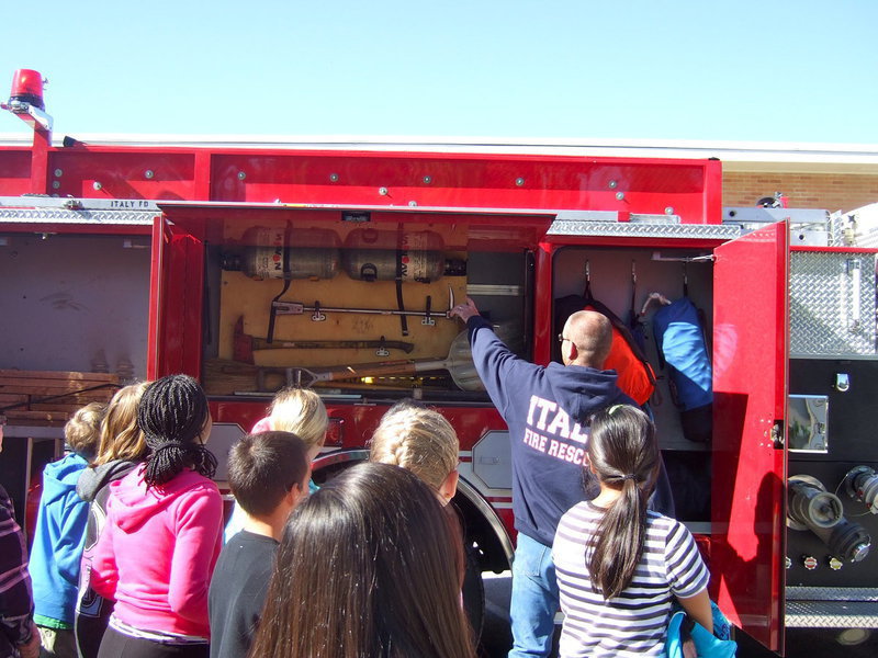 Image: Fireman Brad Chambers teaching students about the oxygen tanks.