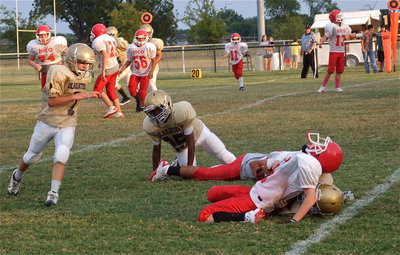 Image: 7th grade Gladiator Clay Riddle(60) folds a Hico runner in half for a loss on the play as teammates Anthony Lusk(25) and Gary Escamilla(7) pursue.
