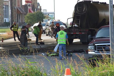 Image: Crews clean up the roadway contaminated by diesel fuel and littered with debris.