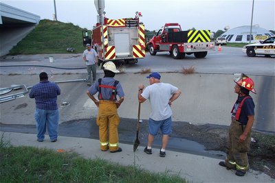 Image: IFD’s Randy Boyd, Jackie Cate and Sal Perales help the water to drain while evaluating the course traveled by the suspect’s out-of-control vehicle.