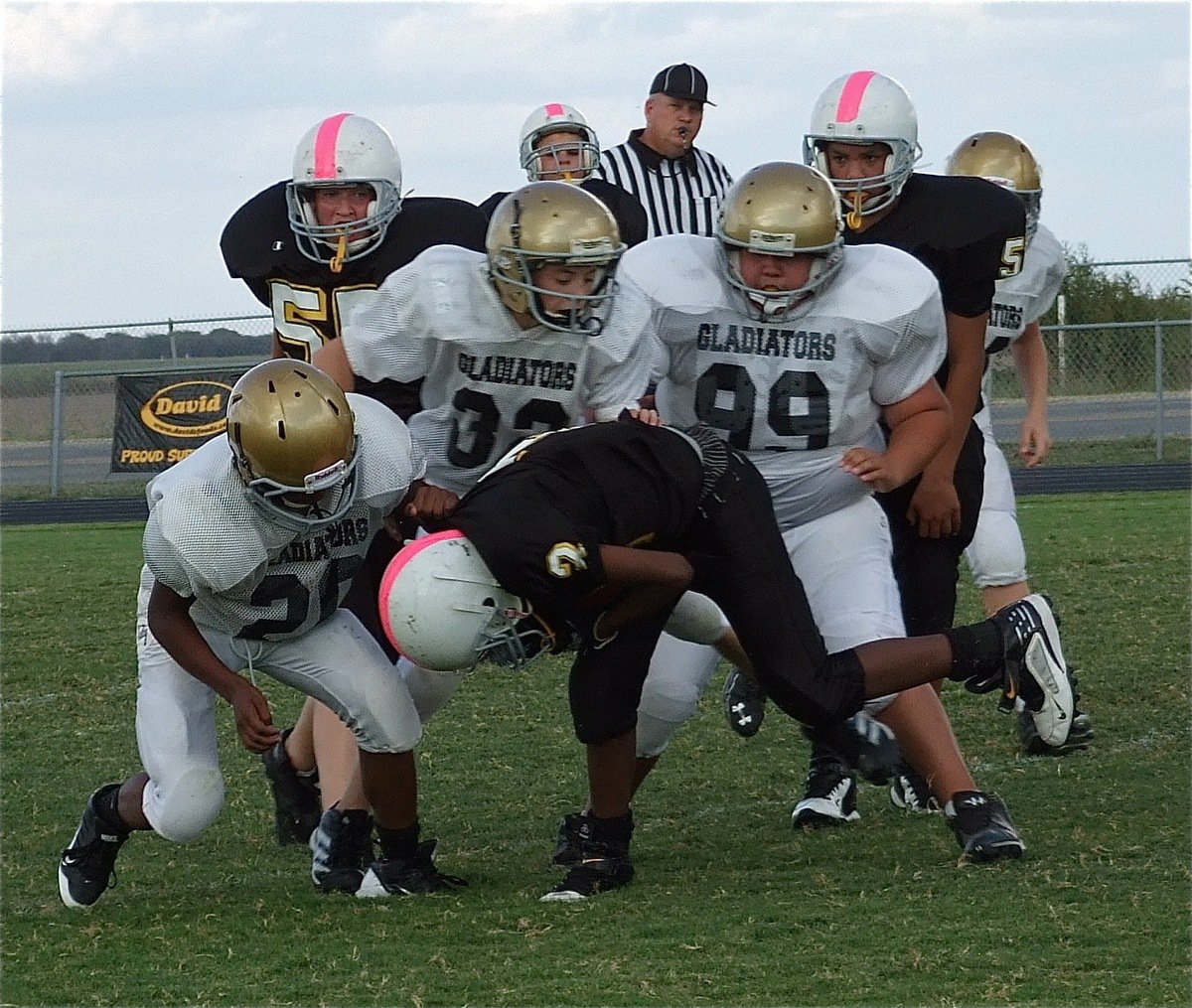 Image: Kendrick Norwood(20), Dylan McCasland(32) and Adrian Acevedo(99) pull down a Cat running back.