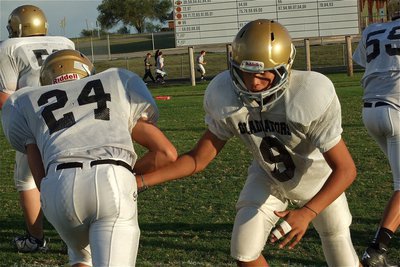 Image: Devonteh Williams(9) hands off to Joe Celis(24) during pre-game warmups before the start of the 8th grade game.