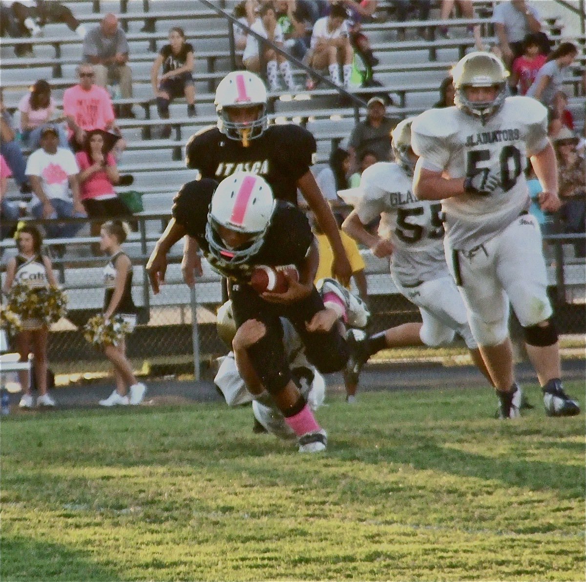 Image: Blake Brewer(30) leg tackles a Cat runner as Aaron Pittman(50) and David De La Hoya(55) give chase.