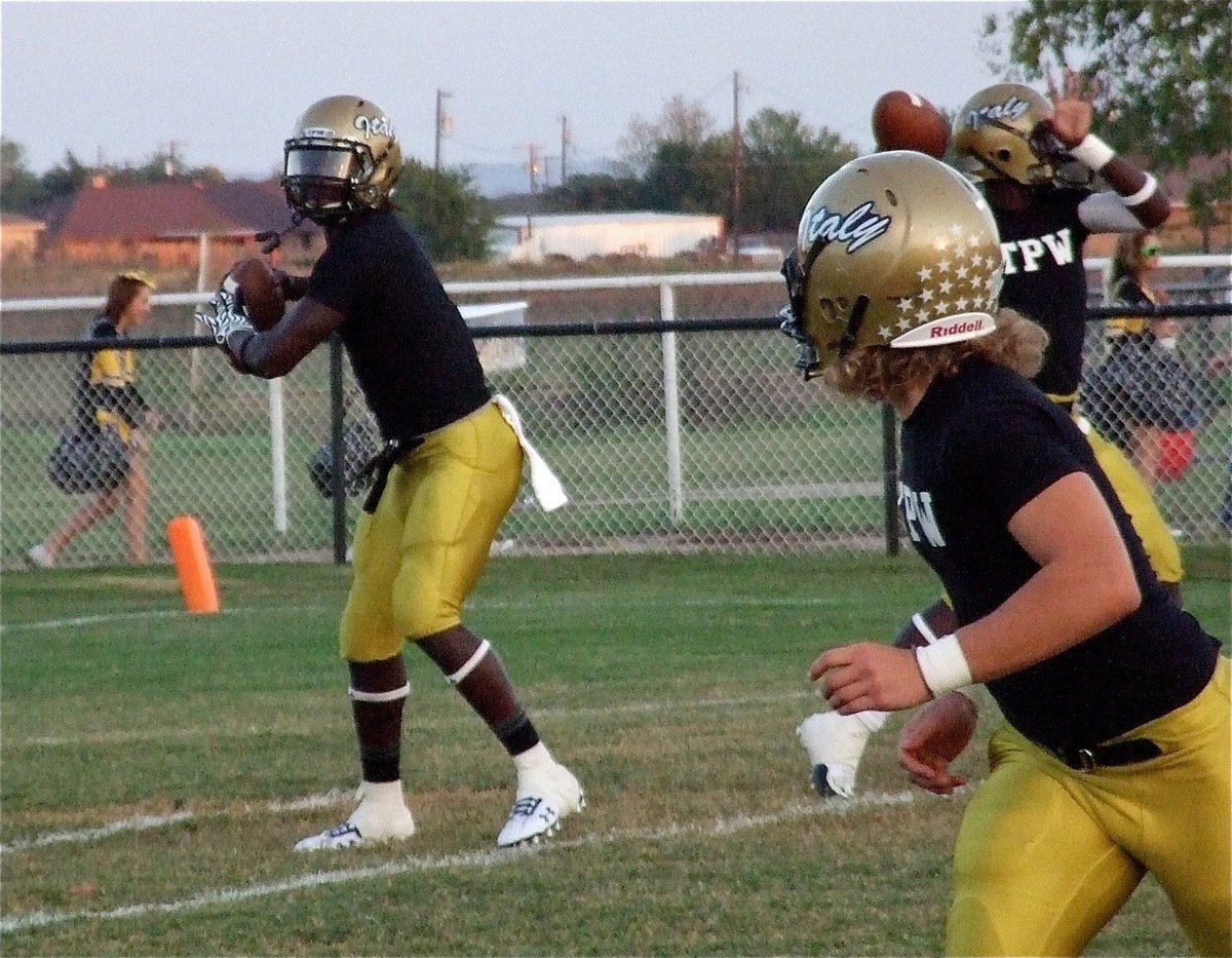 Image: Starting tailback and backup quarterback Ryheem Walker passes to Shad Newman during warmups as starting quarterback Marvin Cox warms up his throwing arm as well.