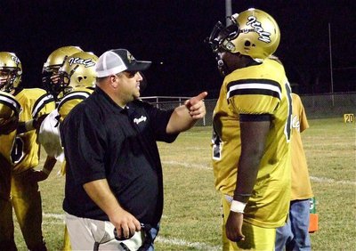 Image: Coach Brian Coffman gives defensive tackle Adrian Reed(64) pointers during a break in the action.