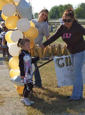 Image: IYAA C-Team cheerleader Mayson Souder accepts a megaphone filled with candy for homecoming as proud mom, Melissa Souder, peeks around the ballloons.