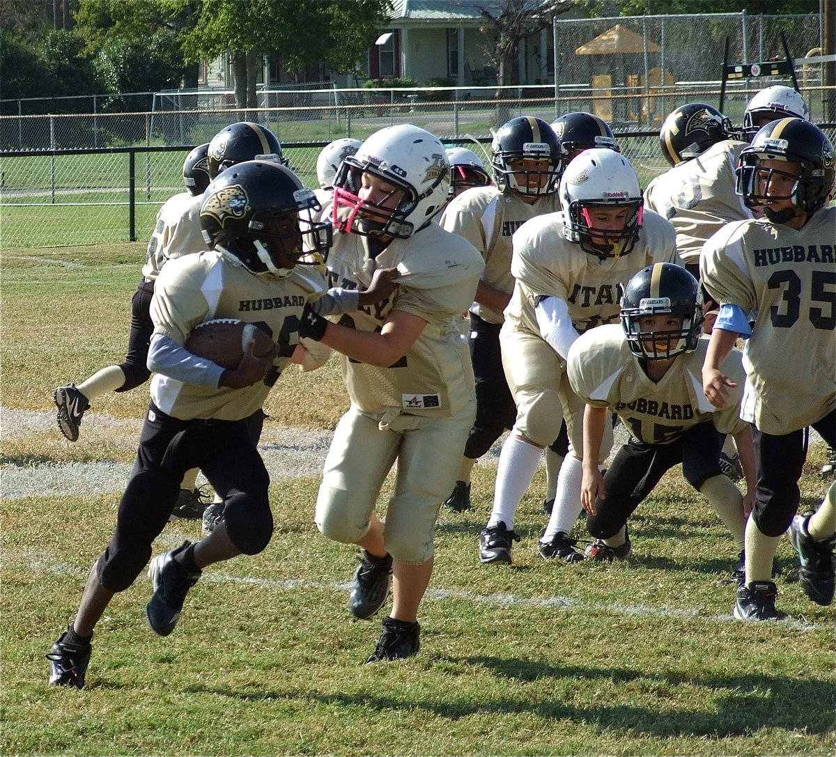 Image: IYAA B-Team Gladiator Jayden Saxon(44) catches a Hubbard Jaguar for a loss in the backfield early in the game.