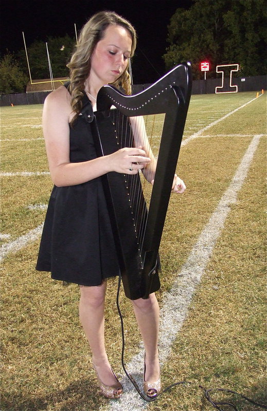 Image: Maddie Pittman plays the harp as the Homecoming Court is introduced along with their escorts.