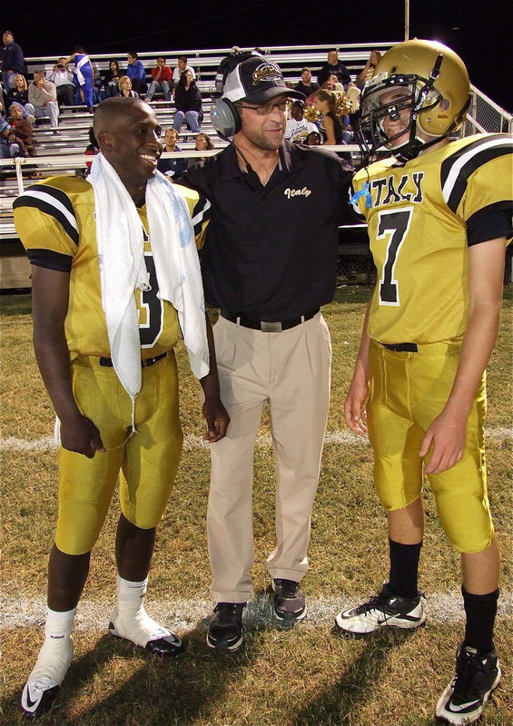 Image: Offensive Coordinator Coach Nate Skelton poses with his quarterbacks Marvin Cox(3) and Ryan Connor(7). Coach Skelton’s offense has averaged 439 yards per game in Italy’s first two district wins.