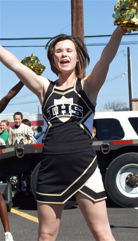 Image: Gladiator Cheerleader Meagan Hooker and her cheer mates perform for fans during the pep rally held downtown on the library parking lot.