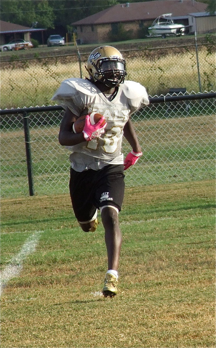 Image: Ryheem Walker(10) dashes away from tacklers.